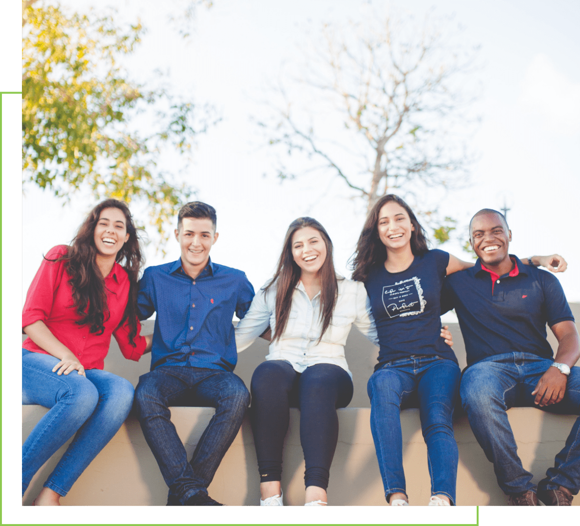 A group of people sitting on top of a wall.